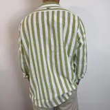 Camisa de lino de corte oversize con diseño de rayas verticales en tonos blanco y tostado, manga larga y cierre frontal con botones.