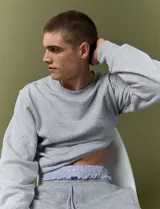 Sweater básico de cuello redondo y manga larga, confeccionado en tejido circular con puños y cuello en tejido canalé.