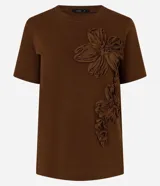 Remera de algodón marrón de manga corta y cuello redondo, con apliques tridimensionales de flores en relieve en el frente.