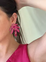 Aros colgantes con forma de hoja de palma color fucsia, con apliques de strass y tachas doradas.