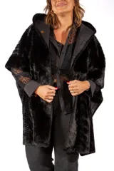 Tapado de piel sintética negra con capucha, diseño de corte amplio y estilo capa.