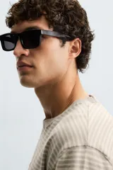 Camiseta de punto de corte relajado (relaxed fit) con cuello redondo y manga corta. Tejido en hilatura de algodón y lino, con rayas horizontales en tonos beige y marrón claro. Los acabados del cuello y los puños son en un tono marrón más oscuro a contraste.