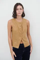 Chaleco de gamuza color caramelo, con cierre frontal de botones y bolsillos laterales simulados.