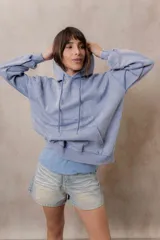 Canguro oversize fucsia con efecto washed, capucha con cordones ajustables al tono, bolsillo frontal tipo canguro y terminaciones de rib en puños y cintura.