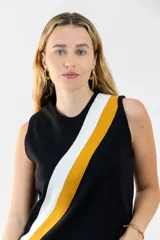 Musculosa negra de tejido de punto con cuello redondo y diseño con franjas diagonales amarillas y blancas.