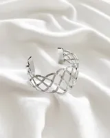 Pulsera rígida plateada con diseño calado de líneas entrecruzadas.