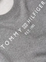 Buzo deportivo gris melange de corte regular con hombros caídos. Presenta el logo de Tommy Hilfiger en blanco centrado en el pecho y un pequeño logo bordado en la manga.