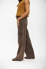 Pantalón tipo jean de corte cargo, color marrón con efecto lavado. Presenta costuras verticales decorativas, bolsillos laterales y diseño de pierna ancha.
