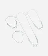 Kit de cuatro collares de diferentes largos confeccionados en metal, con diseño de cadena fina y aplicaciones decorativas de mini pétalos colgantes en tono plateado.