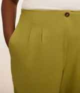 Pantalón carrot de viscolino color verde, con cintura alta, pliegues delanteros y bolsillos laterales.