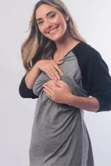Camisón maternal de manga larga con diseño bicolor, cuerpo en gris melange y mangas en negro. Presenta un corte holgado con sistema de lactancia integrado debajo del busto.