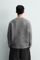 Jersey de punto con acabado cepillado, cuello redondo y manga larga. Presenta un corte boxy fit con terminaciones en rib.
