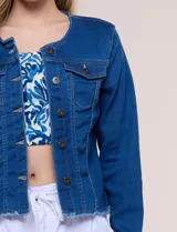 Campera de denim azul oscuro con cuello mao, cierre frontal de botones metálicos, bolsillos plaqué con solapa en el pecho y detalle desflecado en el ruedo.
