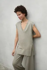 Chaleco de punto en lino color gris, con cuello en V, corte holgado y aberturas laterales en el ruedo.