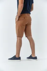 Bermuda tipo chino de gabardina texturizada, con diseño de cinco bolsillos, cierre de cremallera y botón frontal.