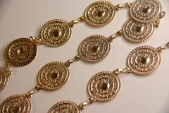 Cinto dorado con chapones redondos con diseño de mandalas.