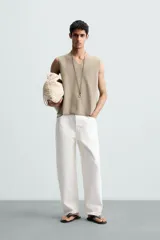Chaleco de punto color beige claro, con cuello en V y corte relajado sin mangas.