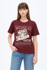 Remera negra de algodón, manga corta, con cuello redondo y diseño gráfico estampado en el pecho que incluye un sol, flores y la leyenda 'Since 1973'.