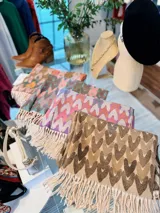 Pashmina rectangular con diseño de corazones entrelazados y flecos en los extremos.