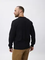 Sweater de punto color negro, con cuello polo y escote en V, de manga larga y diseño ajustado.