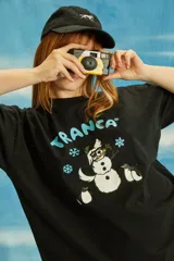 Remera negra de algodón con estampado de un muñeco de nieve y la palabra "Tranca" en celeste.