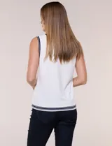Musculosa de tejido de punto color azul marino, de corte recto, con cuello redondo y sisa amplia. Presenta detalles de líneas en contraste de color blanco en el cuello, las sisas y el ruedo.