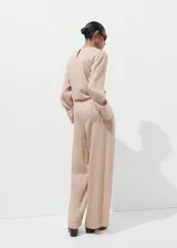 Pantalón de tiro medio color beige con diseño a rayas sutiles, de corte recto y holgado, confeccionado en mezcla de lyocell, viscosa y poliamida.