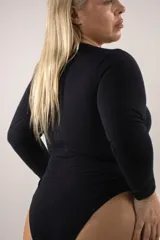 Body negro de algodón elastizado, de manga larga y escote redondo, con detalles de recortes de puntilla con patrón animal print en diagonal en el pecho y el abdomen.