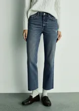 Jeans tiro medio de corte recto y diseño crop en color azul con lavado deslavado y bajo deshilachado. Cuenta con cinco bolsillos, trabillas para cinturón y cierre frontal con cremallera y botón.