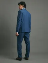Ambo slim fit de color azul, compuesto por saco de dos botones y pantalón de vestir a juego. El tejido cuenta con elastano para mayor comodidad y flexibilidad.