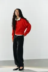 Jeans negro de tiro medio con corte balloon fit, diseño de cinco bolsillos y bajo acabado en puño con abertura y botón.