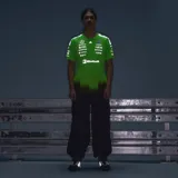 Remera deportiva Adidas de manga corta para hombre, modelo Mercedes-AMG Petronas F1 Team, de color verde fluo con degradado negro en la parte inferior y múltiples logos de patrocinadores impresos en el frente.