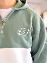 Hoodie de felpa con capucha y medio cierre frontal, diseño en bloques de color celeste y blanco, con bordados decorativos en el pecho.
