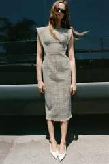 Vestido midi ZARA Woman Collection de tweed gris con sutiles hilos de colores, escote redondo, manga sisa y bajo desflecado con abertura en la espalda. Cuenta con cierre de cremallera oculta.