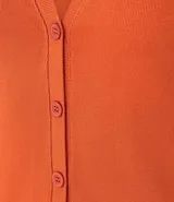 Blusa estilo chaleco, confeccionada en ribana negra, con abotonado delantero, sin mangas y con textura acanalada.