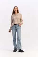 Buzo de punto negro con diseño de trenzas en relieve, cuello redondo y mangas largas.