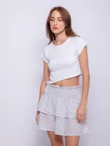 Minifalda negra con estampado de pequeñas flores, diseño de capas con volados y cintura elástica fruncida.