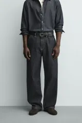 Pantalón chino de denim de algodón rígido, color índigo oscuro sin lavar. Corte baggy fit, tiro medio, con bolsillos frontales y traseros de plastrón. Presenta bordados a contraste en la cintura y en el bolsillo trasero.