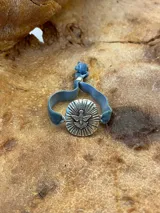 Pulsera con dije plateado con la imagen del Espíritu Santo y cinta de terciopelo elástica color verde petróleo.