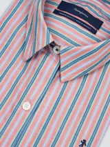 Camisa blanca de algodón, de corte suelto, manga larga y cuello clásico, con cierre frontal de botones y bordado sutil en el pecho.