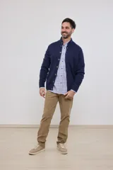 Cardigan de tejido de punto color azul piedra melange, con cuello mao y cierre frontal de botones.