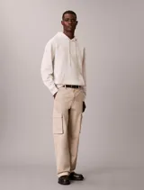 Buzo con capucha de Calvin Klein en color beige, confeccionado en mezcla de algodón y poliéster. Cuenta con bolsillo tipo canguro frontal, cordones ajustables y el monograma de la marca bordado en el pecho.