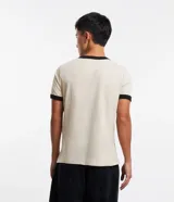 Remera color beige de algodón, modelo baby tee, con cuello y mangas con ribete negro. Estampa en el pecho con la frase "Boys Should Cry".