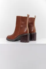 Botas cortas de cuero negro con taco bloque y suela track.