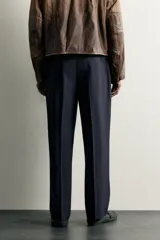Pantalón relaxed fit azul marino confeccionado en tejido con lana, con bolsillos frontales, bolsillos traseros de doble vivo y pliegues en la parte delantera.