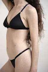 Bombacha semivedetina negra de tejido transparente y suave, con tiras laterales regulables y detalles de argollas metálicas.