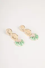 Aros colgantes con dos dijes: uno superior circular con textura y otro inferior con forma de concha marina esmaltada en verde y blanco.