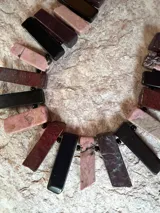 Collar corto elaborado con piedras naturales de rodocrosita, obsidiana y jaspe en tonos rosa, vino, marrón y negro, unidas con cuentas pequeñas.