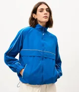 Campera deportiva Get Over de microfibra color azul, con diseño oversized, gola alta, cierre frontal y detalles de líneas en contraste. Cuenta con bolsillos frontales, puños elastizados y dobladillo con cordón ajustable.