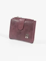 Tarjetero monedero color bordó de cuero vegano con cierre de broche y cierre superior con cremallera.
